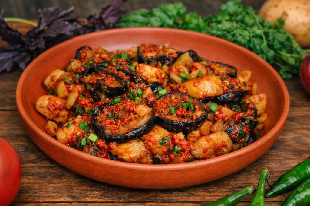 Adschapsandali, traditionelles georgisches Gemüsegericht mit Auberginen, Kartoffeln und Tomaten in roter Sauce